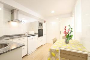 a kitchen with a table with a vase of flowers on it at MARCOS Apt in Port de Pollensa