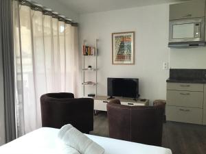 a living room with a television and a desk with chairs at Studio 7 Promenade des Anglais in Nice