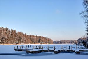 eine Anlegestelle auf einem See mit Schnee auf dem Wasser in der Unterkunft Istra Holiday Hotel in Trusovo