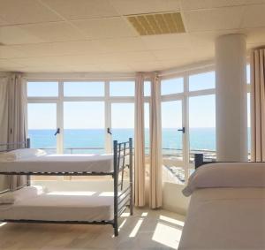 a room with four beds and a view of the ocean at Albergue Club Náutico de Águilas in Águilas