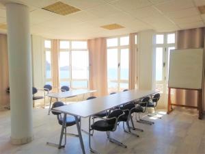 uma sala de reuniões com mesas e cadeiras e um quadro branco em Albergue Club Náutico de Águilas em Águilas