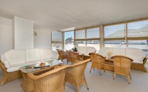 a living room with white furniture and a table and chairs at Hôtel Eliseo in Lourdes