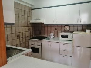 a kitchen with white cabinets and a microwave at 1 Bedroom Apartment with stunning sea view in Arona