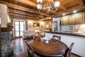 a kitchen and living room with a wooden table and a dining room at Casa Marimanha by SeaMount Rentals in Salardú