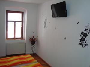 Habitación con TV en la pared y ventana. en Apartament Miruna Sibiu Filarmonicii, en Sibiu