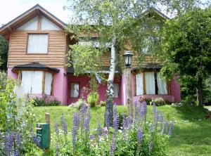 a pink house with purple flowers in front of it at Verde Sol in San Carlos de Bariloche