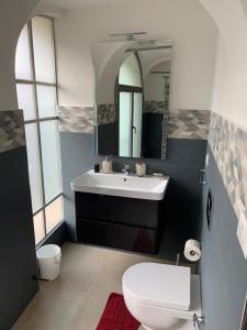 a bathroom with a sink and a toilet and a mirror at Casa Sigiu - La Piazza in Rieti
