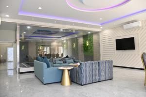 salon z niebieską kanapą i telewizorem w obiekcie SHALLY VILLAGE w mieście Dammam