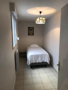 a bedroom with a bed and a window and a chandelier at Centr’Appart. in Saint-Omer