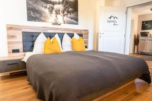 um quarto com uma cama grande e almofadas amarelas em Apartment zu Hollenau em Going