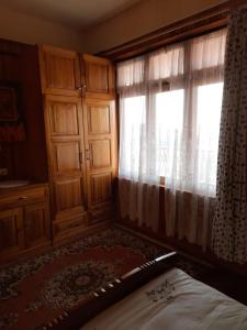 Schlafzimmer mit einem Bett und einem Fenster mit Vorhängen in der Unterkunft SEWANS PLACE Homestay in Mirik