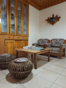 a living room with a wooden table and two chairs at SEWANS PLACE Homestay in Mirik