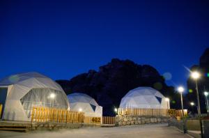a group of domes with lights in them at night at The Rock Camp Petra in Wadi Musa