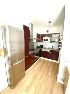 een keuken met bruine kasten en een roestvrijstalen koelkast bij App. Seyrl im Haus Karoline in Schladming