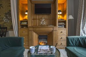 a living room with a fireplace and a tv at La Venelle du Bassin in Honfleur