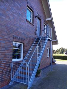 a staircase on the side of a brick building at Helgas Ferienwohnung 4 Sterne in Südbrookmerland