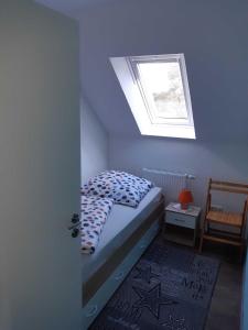 ein kleines Schlafzimmer mit einem Bett und einem Fenster in der Unterkunft Helgas Ferienwohnung 4 Sterne**** in Südbrookmerland