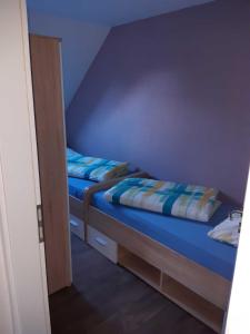 a bedroom with two beds with blue walls at Helgas Ferienwohnung 4 Sterne in Südbrookmerland