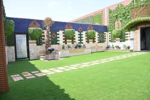 SHALLY VILLAGE في الدمام: ساحة مبنى مع حديقة خضراء