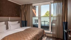 ein Hotelzimmer mit einem Bett und einem großen Fenster in der Unterkunft Innspire Hotel in München