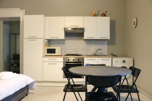 a kitchen with white cabinets and a table and chairs at Washington Suite in Milan