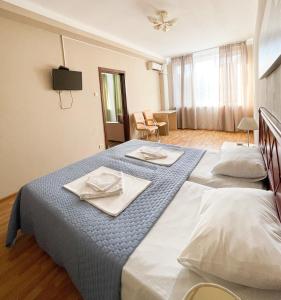 a bedroom with two beds with plates and napkins on them at Hotel Cheshskiy Dom in Adler