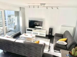 a living room with a couch and a tv at Vakantieappartement Emiel Centrum Oostende in Ostend