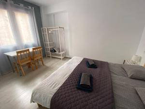een slaapkamer met een bed en een tafel en stoelen bij Cozy apartment Alicante in Alicante