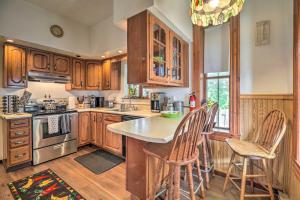 a kitchen with wooden cabinets and a table and chairs at Historic Apartment - Half Mi to Lake Champlain! in Plattsburgh