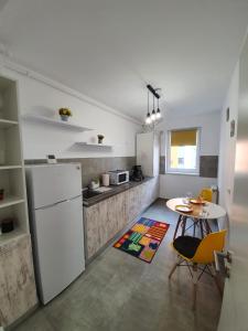 eine Küche mit einem weißen Kühlschrank und einem Tisch in der Unterkunft Studio By Raisa in Braşov