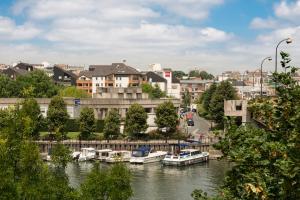 a group of boats docked on a river in a city at ibis Nogent Sur Marne in Nogent-sur-Marne