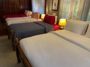 a room with three beds and a couch at HomeandHomestay Chiang Kham in Chiang Kham