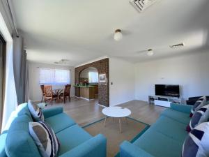 a living room with a blue couch and a table at Albury Garden Court Motel in Albury