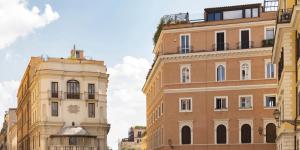 zwei hohe Gebäude nebeneinander auf einer Straße in der Unterkunft All'obelisco in Rom