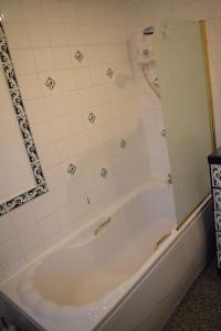 een badkamer met een wit bad en een spiegel bij Great base for a Yorkshire adventure in Old Malton