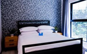 Stay Ulo at Atholl Gate في جوهانسبرغ: غرفة نوم بسرير وورق جدران ازرق وابيض