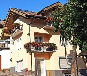 a building with flower boxes on the balconies at B&B Casa Riz in Castello di Fiemme