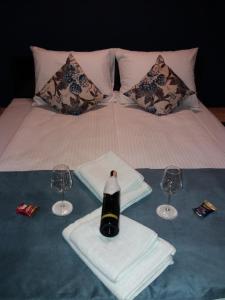a bed with a bottle of wine and two glasses at Motel Bihać in Bihać