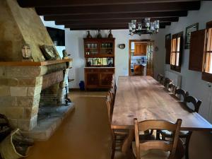 a dining room with a long table and a fireplace at Masía Can Janet in Arbúcies
