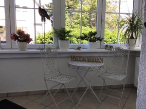 two chairs and a table in a room with windows at Ferienwohnung Zur Stollenlinde in Goslar