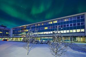 an office building with the aurora in the sky at Reykjavik Natura - Berjaya Iceland Hotels in Reykjavík