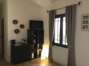 uma sala de estar com televisão e janela em Petit cocon dans le Luberon em Lauris