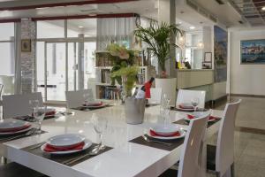 a dining room with a white table and chairs at Apartments and Rooms Villa Niko in Trogir