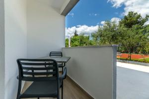 a table and chair on a balcony with a view at Apartments Villa Niko in Trogir