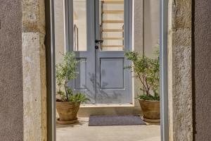an open door with potted plants on a porch at Casa Santa Maria Vacation House in Mali Lošinj