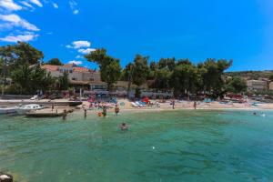 un grupo de personas en el agua en una playa en Apartments and Rooms Villa Niko en Trogir