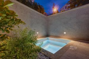 a swimming pool in the corner of a building with a plant at Casa Santa Maria, urban villa in Mali Losinj in Mali Lošinj