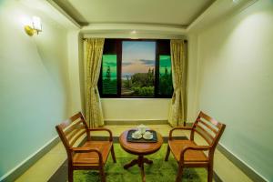 una camera con tavolo, sedie e finestra di Victoria View Boutique Hotels Kigo a Entebbe