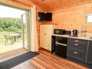 a kitchen with a stove and a table with a balcony at Hwyl in Llandrindod Wells