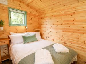 una camera con un letto in una cabina di legno di Hwyl a Llandrindod Wells